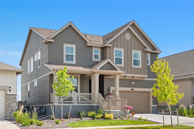 864 Clover Loop, Erie, CO 80026 - view of front of home with board and batten siding, a porch, an attached garage, concrete driveway, and roof with shingles