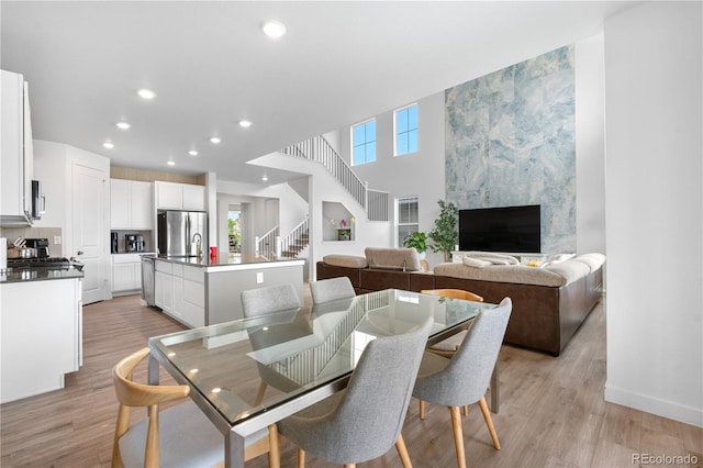 864 Clover Loop, Erie, CO 80026 - dining area with plenty of natural light, light wood-style flooring, recessed lighting, stairs, and a fireplace