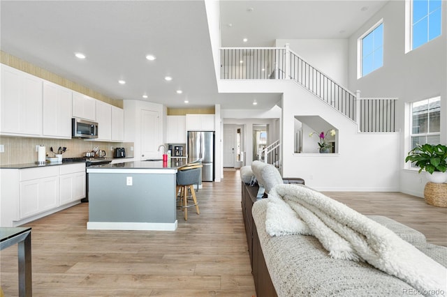 864 Clover Loop, Erie, CO 80026 - kitchen featuring stainless steel appliances, open floor plan, recessed lighting, an island with sink, and a breakfast bar