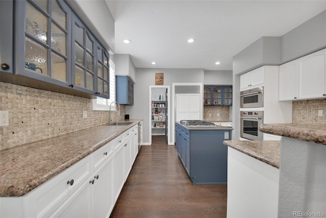 877 Eldorado Dr, Superior, CO 80027 - kitchen with a sink, backsplash, dark wood-style floors, glass insert cabinets, and light stone countertops