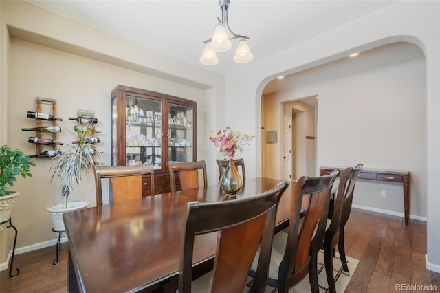 dining area with dark hardwood / wood-style flooring and a chandelier