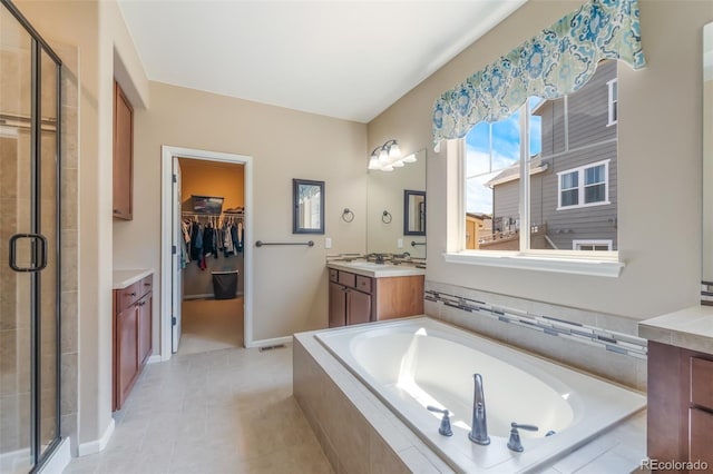 bathroom with tile patterned flooring, vanity, and shower with separate bathtub