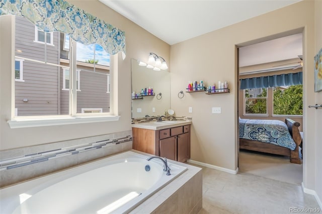 bathroom featuring tile patterned floors, a relaxing tiled tub, and vanity