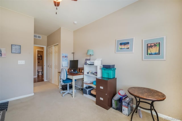 carpeted home office featuring ceiling fan