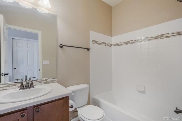 bathroom with vanity, toilet, and tasteful backsplash