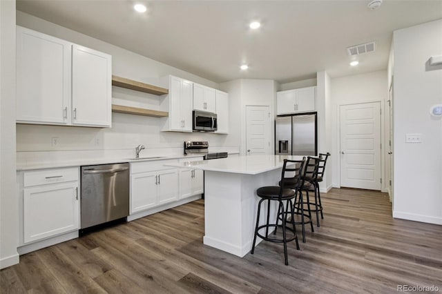 503 S Rollie Ave Unit 13C, Fort Lupton, CO 80621 - kitchen with stainless steel appliances, a kitchen bar, white cabinetry, a center island, and recessed lighting