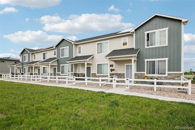 503 S Rollie Ave Unit 13C, Fort Lupton, CO 80621 - rear view of property with board and batten siding, stone siding, and a residential view