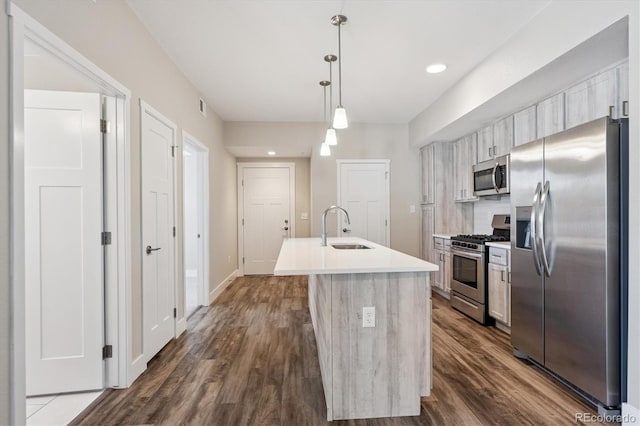 290 S Cherrywood Dr Unit 202, Lafayette, CO 80026 - kitchen with stainless steel appliances, a kitchen island with sink, dark wood-style floors, backsplash, and light countertops