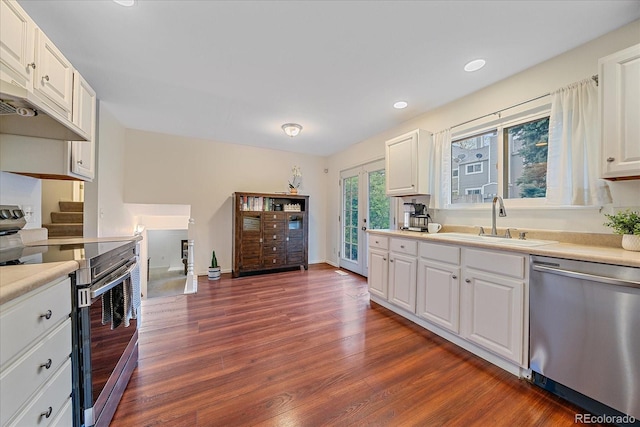 kitchen with appliances with stainless steel finishes, a sink, light countertops, dark wood-style flooring, and recessed lighting