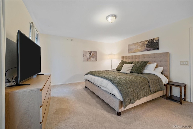 bedroom with light colored carpet and baseboards