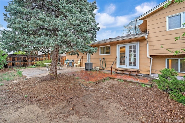 rear view of property with fence, a patio, and central AC unit
