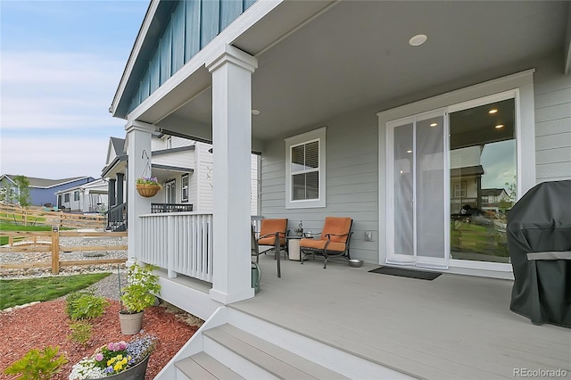 wooden deck with a grill and covered porch