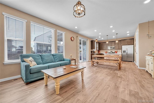 living room featuring a chandelier and light wood-type flooring