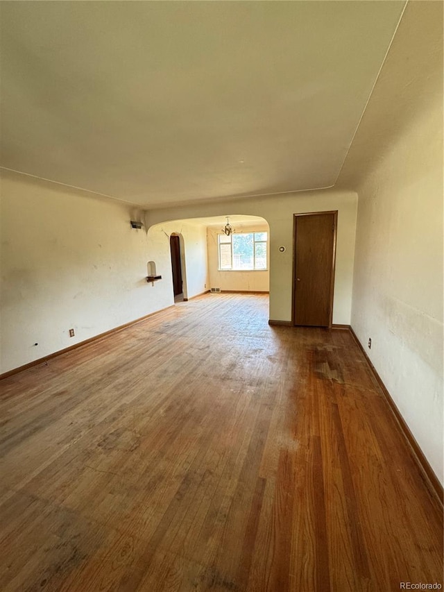 460 Yates St, Denver, CO 80204 - unfurnished living room with arched walkways and wood finished floors
