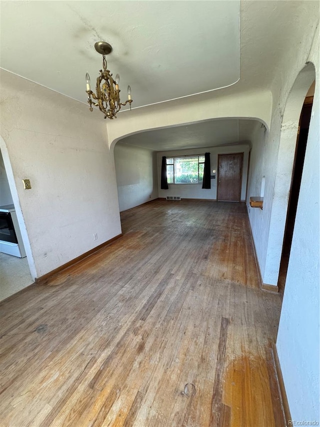 460 Yates St, Denver, CO 80204 - unfurnished dining area with arched walkways, hardwood / wood-style floors, and a chandelier