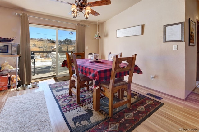 dining space with ceiling fan, light hardwood / wood-style floors, and lofted ceiling