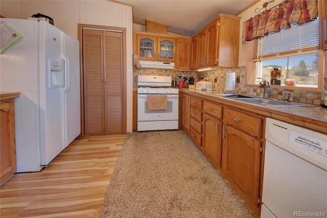 kitchen featuring backsplash, sink, white appliances, and light wood-type flooring