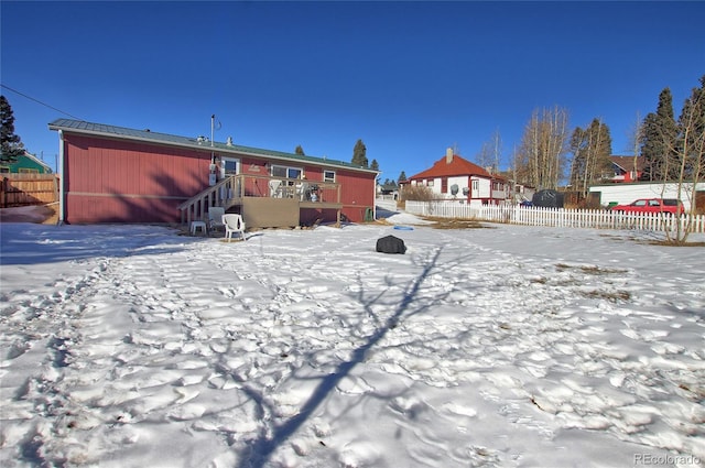 snow covered rear of property featuring a deck