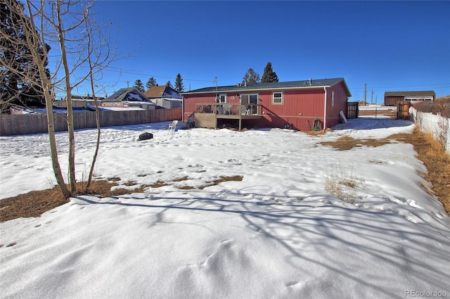 snow covered house featuring a wooden deck