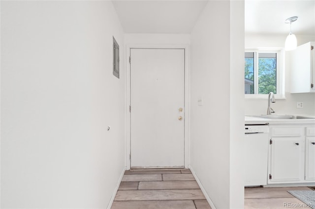 entryway with a sink, light wood finished floors, and baseboards