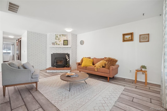 living room with wood finished floors and a wood stove