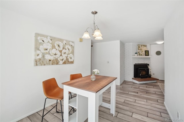 dining room featuring a chandelier, light wood-type flooring, and baseboards