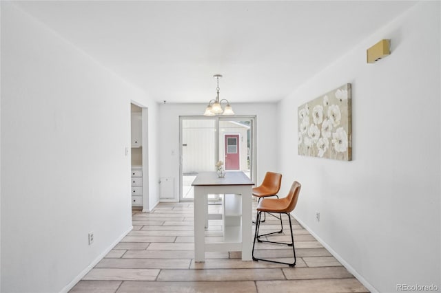 dining room with a chandelier, light wood-style floors, and baseboards