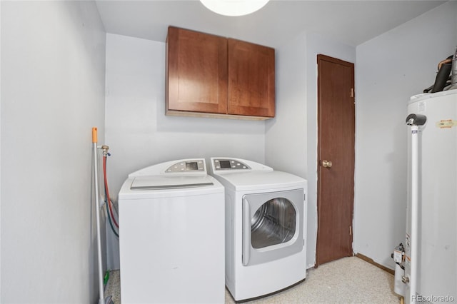 clothes washing area with gas water heater, cabinet space, and washing machine and dryer