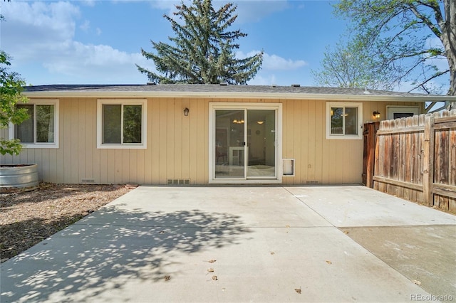 back of property featuring fence and a patio