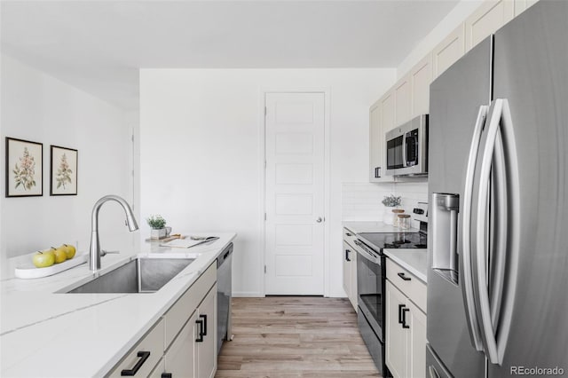 6117 Easton Cir, Frederick, CO 80504 - kitchen with stainless steel appliances, light wood-style floors, tasteful backsplash, light stone countertops, and white cabinetry