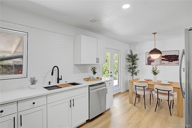 3055 S Winona Ct, Denver, CO 80236 - kitchen featuring stainless steel appliances, white cabinets, light wood-type flooring, light countertops, and recessed lighting