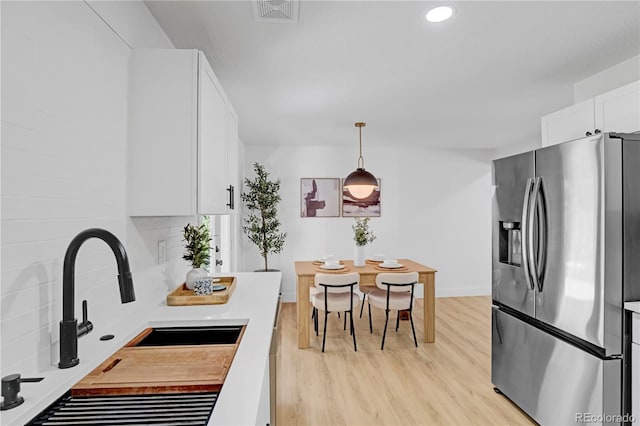 3055 S Winona Ct, Denver, CO 80236 - kitchen with stainless steel refrigerator with ice dispenser, light wood-style flooring, white cabinetry, light countertops, and recessed lighting
