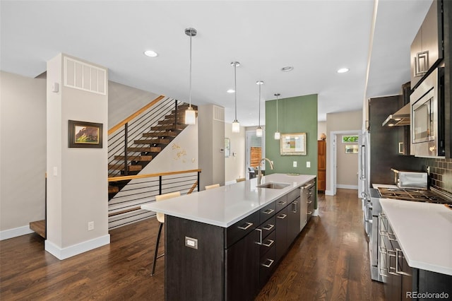 2730 Hooker St, Denver, CO 80211 - kitchen with an island with sink, a kitchen breakfast bar, dark wood finished floors, recessed lighting, and light countertops