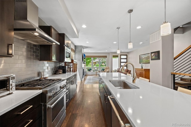 2730 Hooker St, Denver, CO 80211 - kitchen with wall chimney exhaust hood, stainless steel appliances, light countertops, dark wood-type flooring, and open floor plan