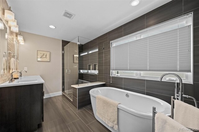 2730 Hooker St, Denver, CO 80211 - bathroom with vanity, a shower stall, a freestanding tub, recessed lighting, and tile walls