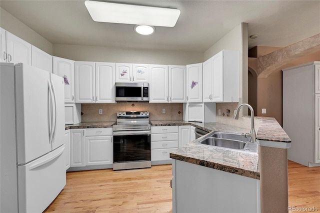 kitchen with white cabinetry, sink, kitchen peninsula, and appliances with stainless steel finishes