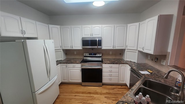 kitchen featuring stainless steel appliances, sink, white cabinets, and light hardwood / wood-style floors