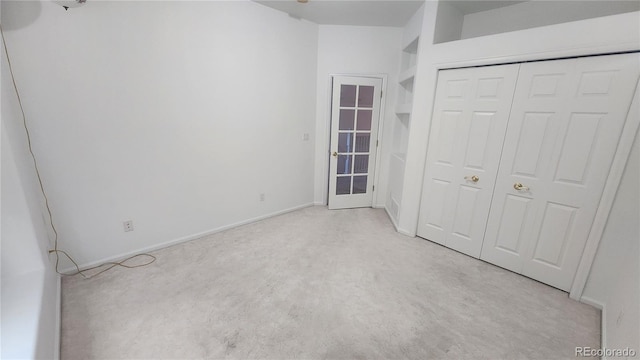 unfurnished bedroom with light carpet and a closet