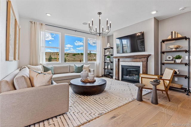 16554 W 93rd Way, Arvada, CO 80007 - living area featuring wood finished floors, a chandelier, a glass covered fireplace, and recessed lighting