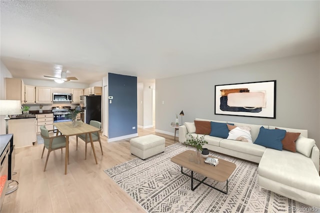 living room featuring light hardwood / wood-style flooring and ceiling fan