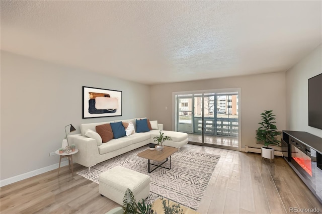 living room with light wood-type flooring, a textured ceiling, and a baseboard heating unit