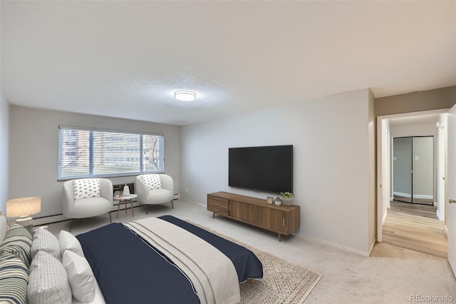 carpeted bedroom featuring baseboard heating and a textured ceiling