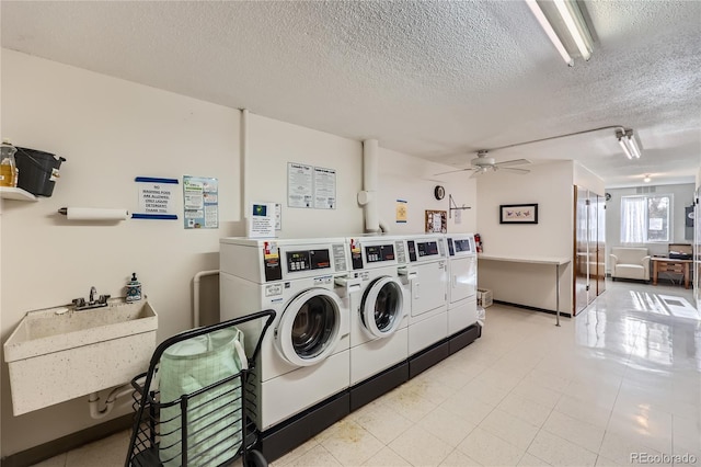 washroom featuring sink, ceiling fan, a textured ceiling, and independent washer and dryer