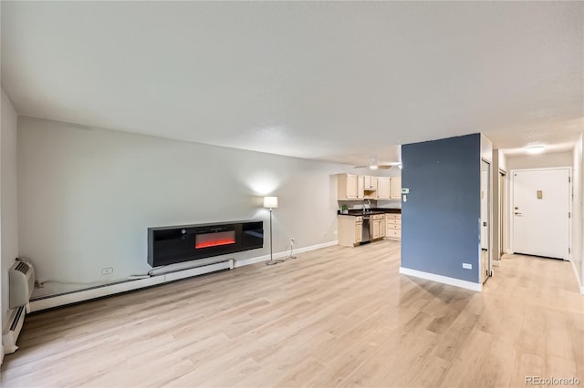 unfurnished living room with light wood-type flooring and a baseboard radiator