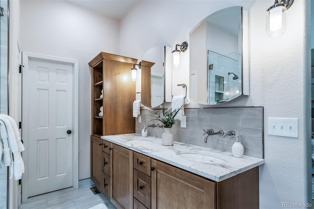 full bath with tasteful backsplash, vanity, and a shower with shower door