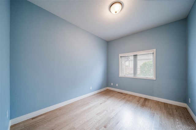spare room featuring wood finished floors and baseboards