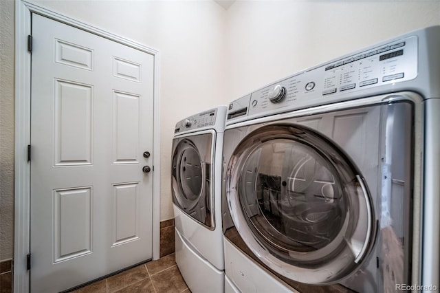 clothes washing area featuring independent washer and dryer and dark tile patterned flooring
