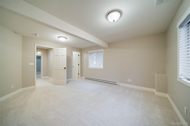 spare room with baseboard heating, light carpet, and baseboards
