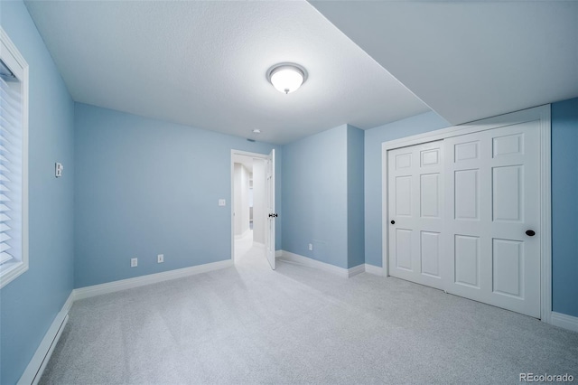 unfurnished bedroom with carpet floors, baseboards, and a closet