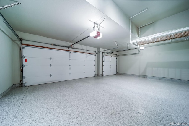 garage featuring a garage door opener and baseboards